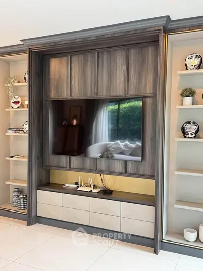 Luxurious living room with elegant built-in TV unit and decorative shelving.