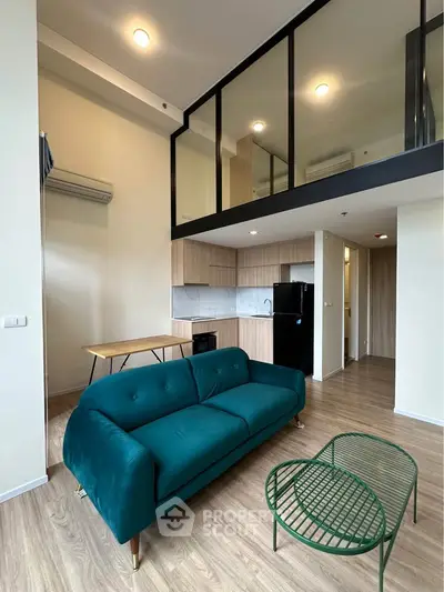 Modern loft apartment with stylish green sofa and open kitchen layout
