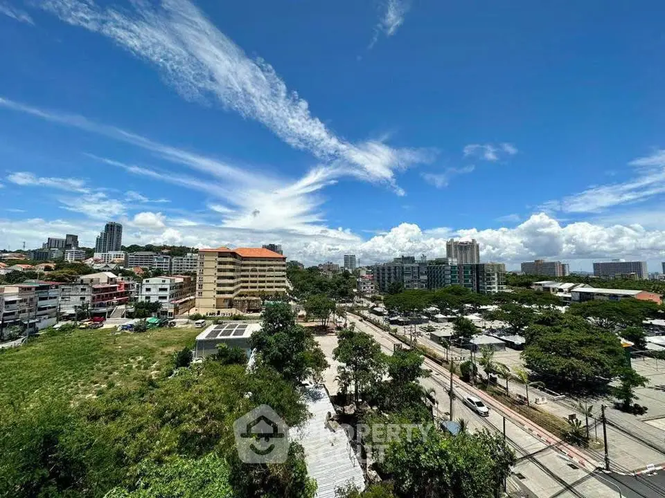Stunning cityscape view with lush greenery and vibrant skyline under a clear blue sky.