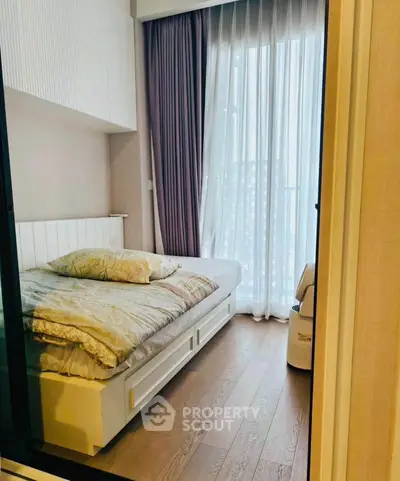 Cozy bedroom with natural light and elegant curtains, perfect for relaxation.