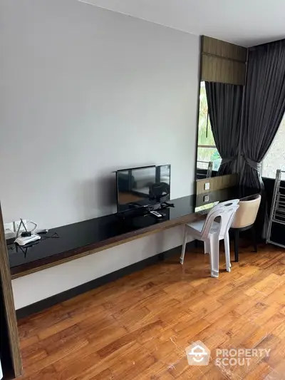 Modern study area with sleek desk and flat-screen TV in stylish apartment