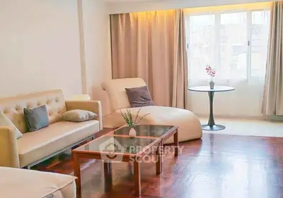 Spacious living room with elegant furniture and large window offering natural light.