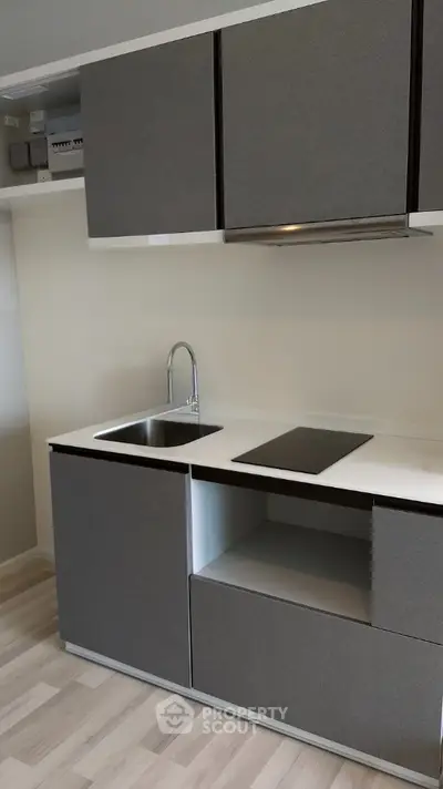 Modern kitchen with sleek cabinets and induction cooktop in minimalist design.