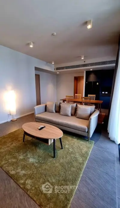Spacious modern living room with cozy sofa and dining area, perfect for relaxation and entertaining.