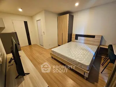 Modern bedroom with wooden flooring and stylish furniture in a cozy apartment.
