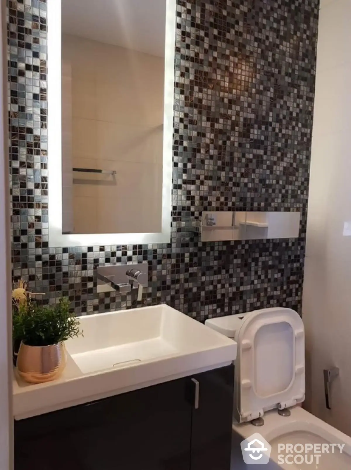 Modern bathroom with stylish mosaic tiles and illuminated mirror