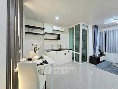 Modern open-layout kitchen and living area with sleek design and ample natural light.