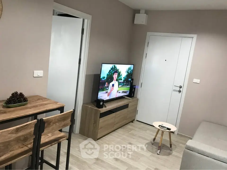 Modern living room with stylish furniture and wall-mounted TV in a cozy apartment.