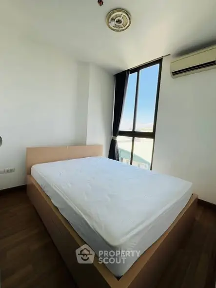 Bright bedroom with large window and modern air conditioning unit