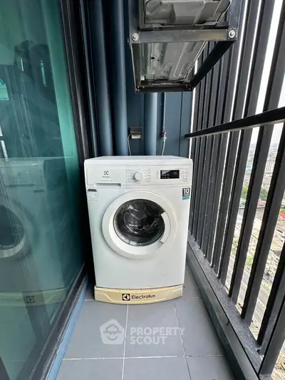 Compact balcony with washing machine and city view, perfect for urban living convenience.