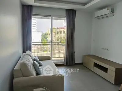 Modern living room with large window and city view, featuring a comfortable sofa and sleek air conditioning unit.