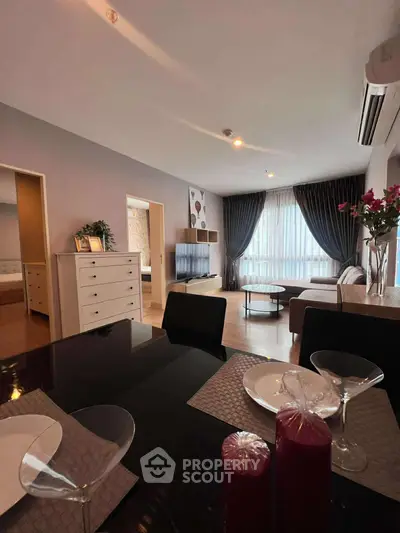 Modern living room with elegant decor and dining area, featuring large windows and stylish furniture.