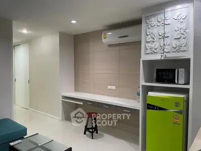 Modern apartment interior with sleek design, featuring air conditioning and compact kitchen appliances.