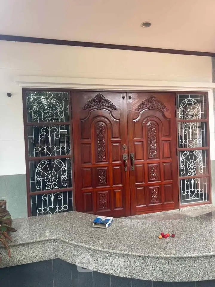 Elegant wooden double doors with intricate carvings and decorative side panels, perfect for a grand entrance.