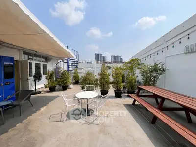 Spacious rooftop terrace with seating and city views, perfect for outdoor gatherings.
