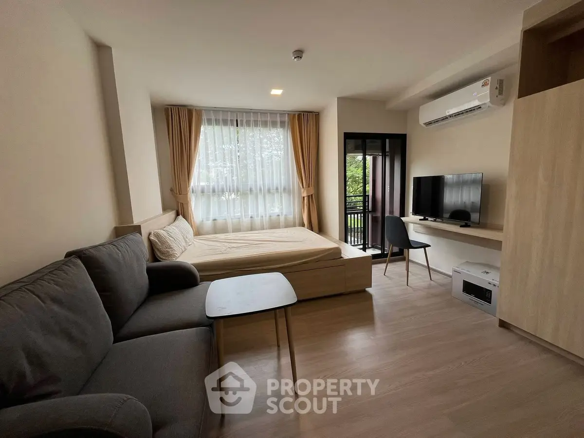Modern studio apartment with cozy living area and balcony view