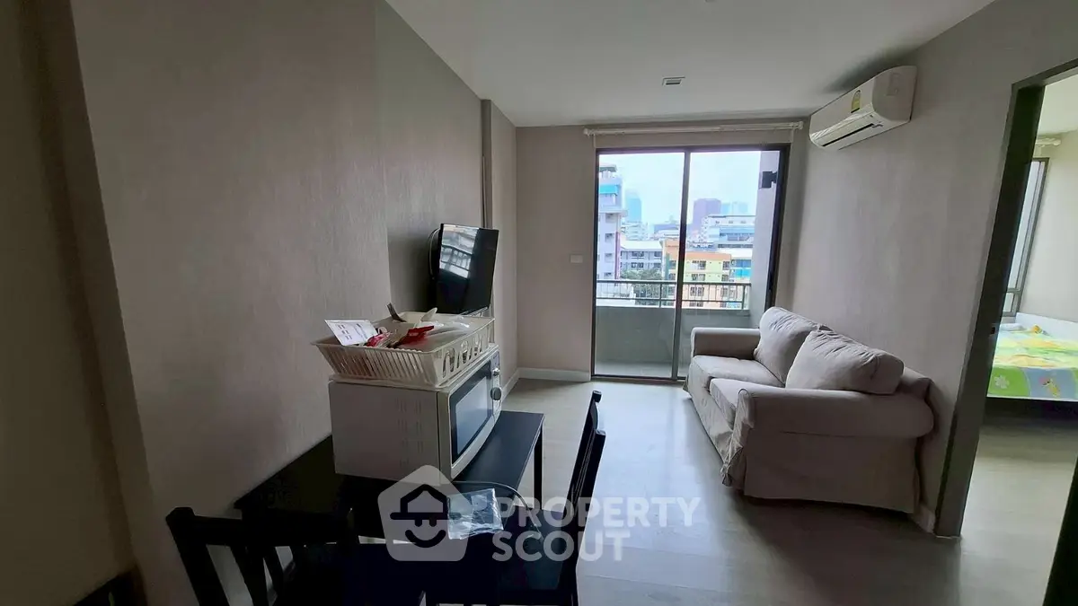 Modern living room with city view, cozy sofa, and dining area in a stylish apartment.