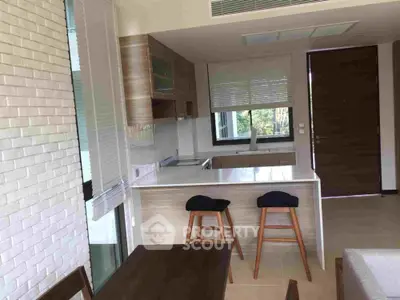Modern kitchen with open layout, sleek cabinetry, and breakfast bar, ideal for entertaining and casual dining in a stylish home.