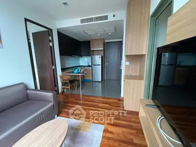 Modern living room with open kitchen layout and wooden flooring