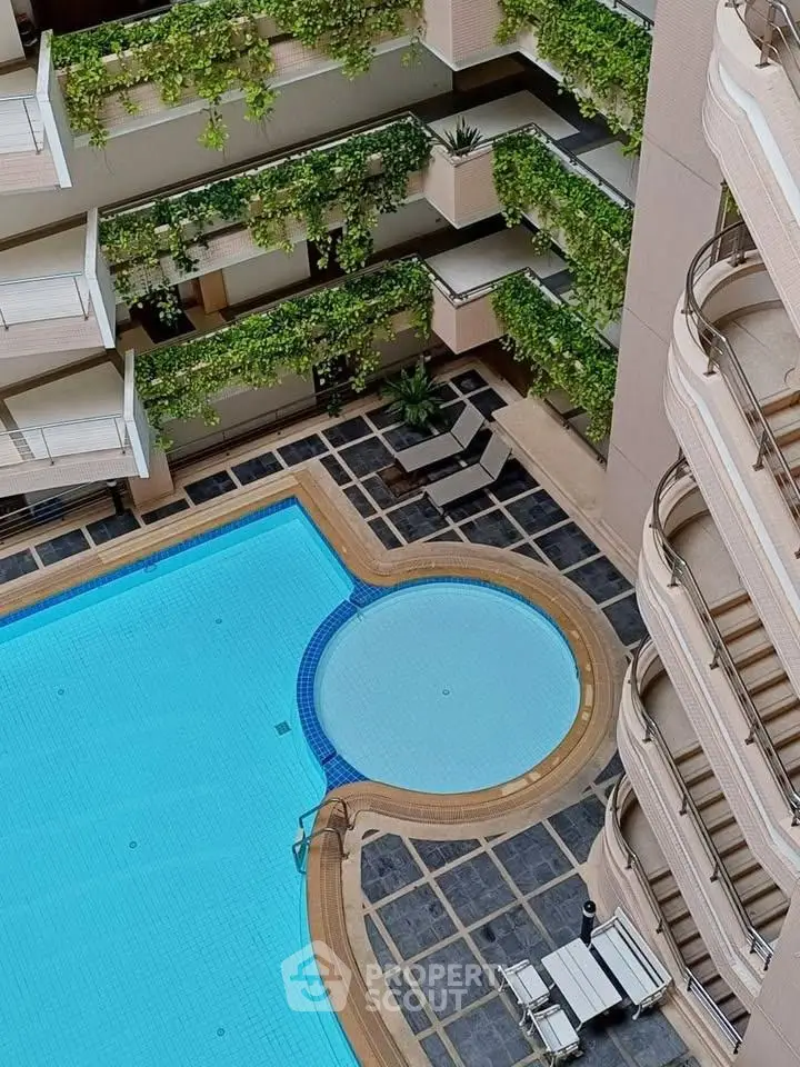 Luxurious apartment complex with stunning pool and lush greenery, perfect for relaxation and leisure.