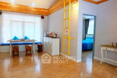 Charming open-plan living area with dining nook and cozy bedroom view.