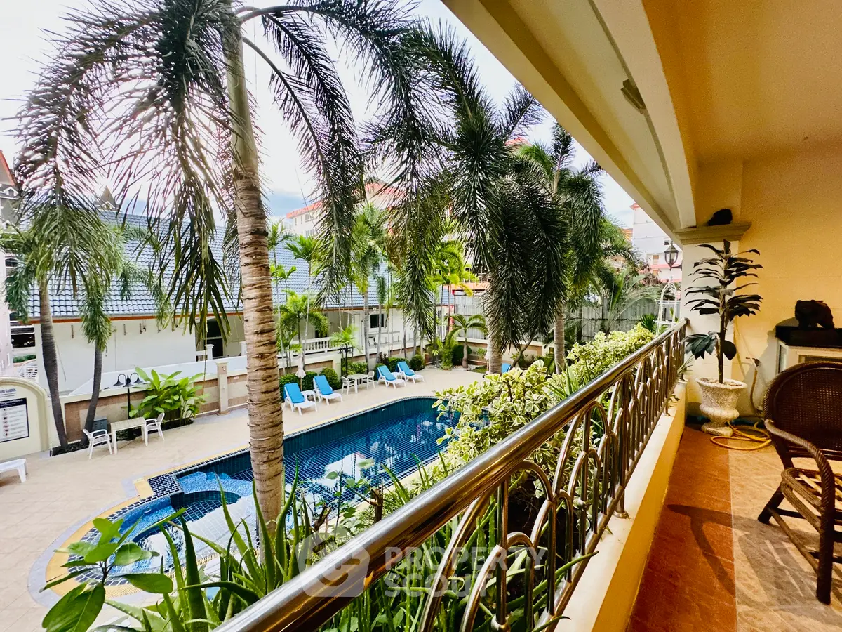 Luxurious tropical poolside view from a spacious balcony with lush greenery.
