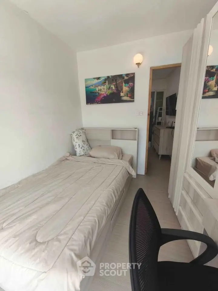 Cozy bedroom with single bed, modern decor, and wall art in a bright apartment.