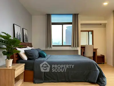 Spacious bedroom with modern decor and city view, featuring a cozy bed and stylish furniture.