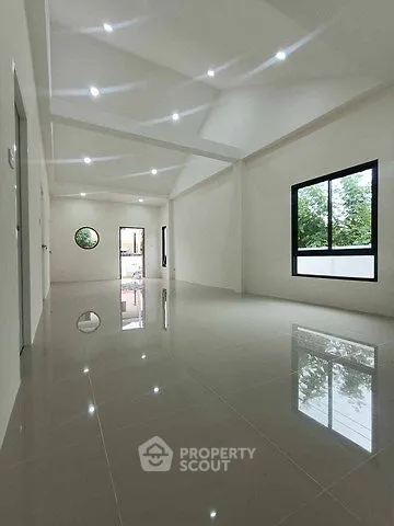 Spacious modern interior with glossy tiled floors and large windows offering natural light.