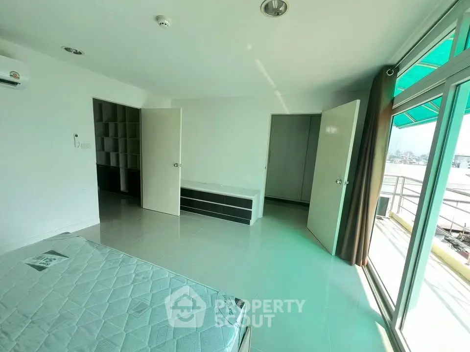 Spacious bedroom with balcony access and ample natural light