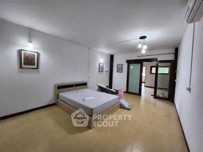 Spacious bedroom with modern lighting and minimalist decor, perfect for relaxation and comfort.