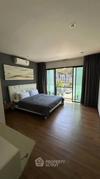 Spacious bedroom with modern decor and large windows offering a stunning view, perfect for relaxation.