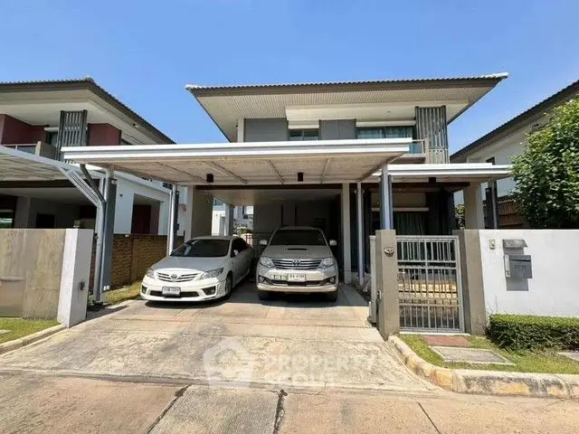 Modern two-story house with carport and parked cars in a suburban neighborhood.