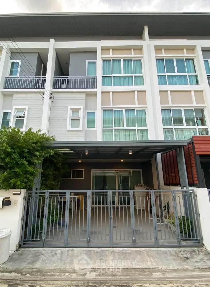 Modern townhouse exterior with gated entrance and large windows