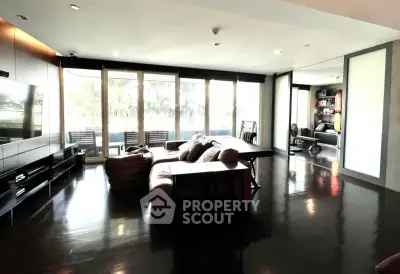 Spacious modern living room with large windows and sleek dark flooring