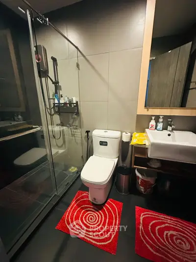 Modern bathroom with glass shower and stylish red rugs