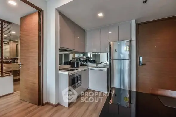 Modern kitchen with sleek cabinetry and stainless steel appliances in a stylish apartment.