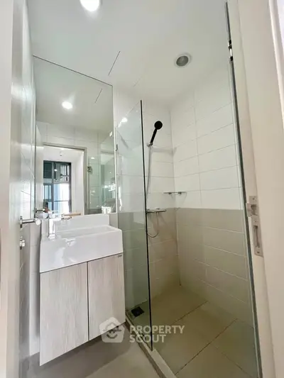 Modern bathroom with sleek design, featuring a glass shower enclosure and stylish vanity unit.
