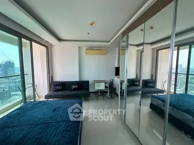 Modern bedroom with mirrored wardrobe and city view balcony in high-rise apartment.