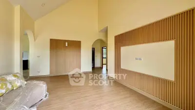 Spacious modern living room with high ceilings and elegant wood paneling.