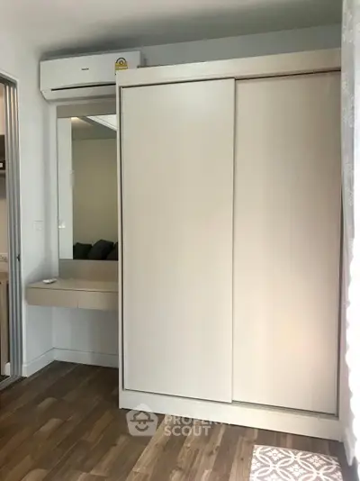 Modern bedroom with sleek sliding wardrobe and air conditioning unit