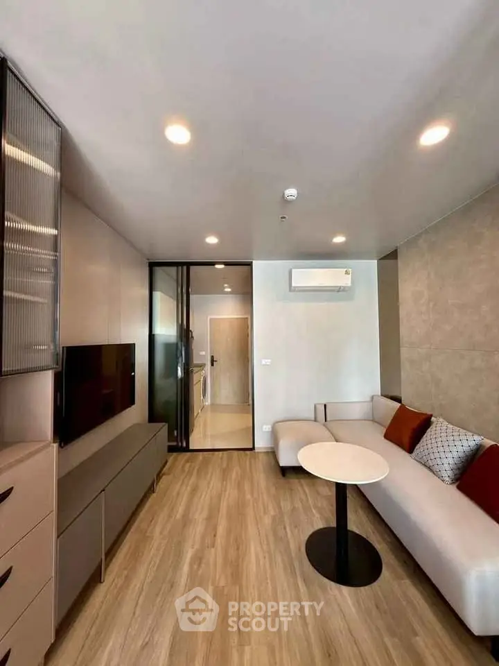 Modern living room with sleek design, featuring a cozy sofa, stylish table, and built-in TV unit.