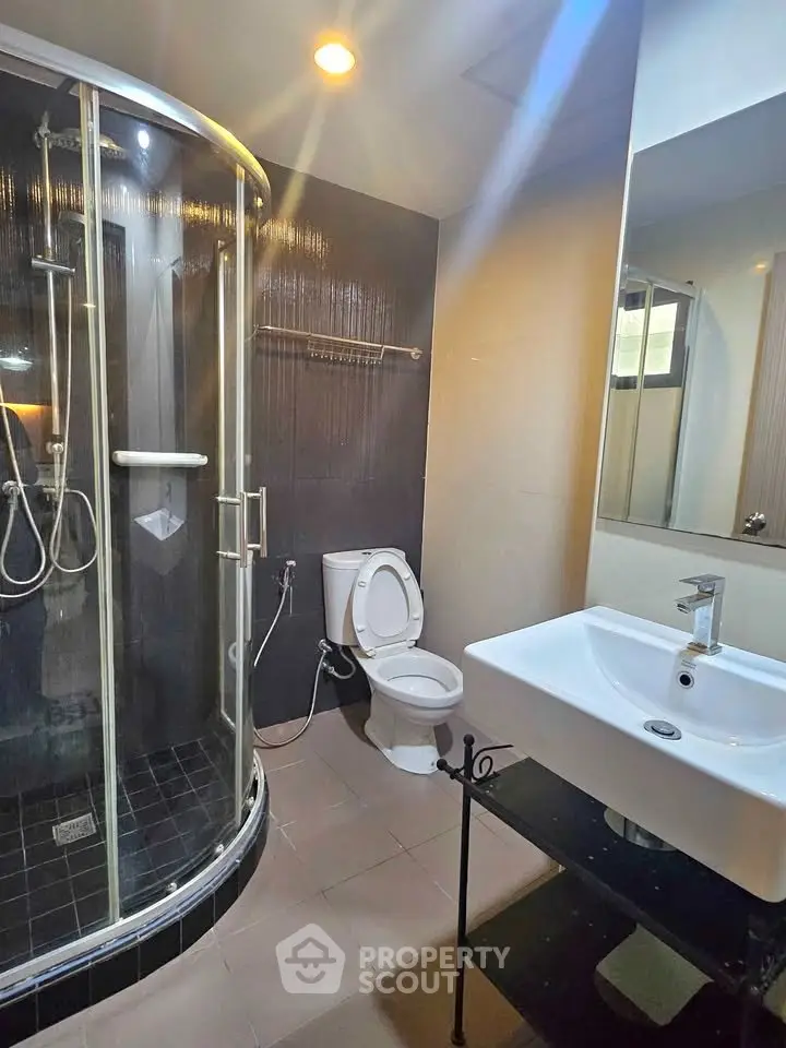 Modern bathroom with glass shower and sleek fixtures in a contemporary apartment.
