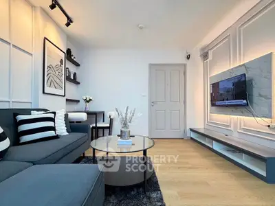 Modern living room with stylish decor and wall-mounted TV, featuring sleek furniture and elegant lighting.