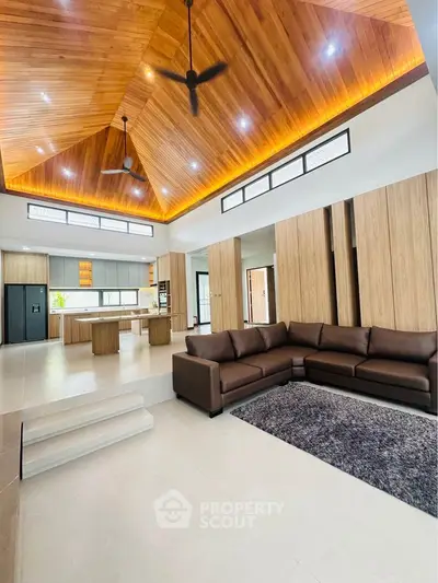 Spacious modern living room with high wooden ceiling and open kitchen layout