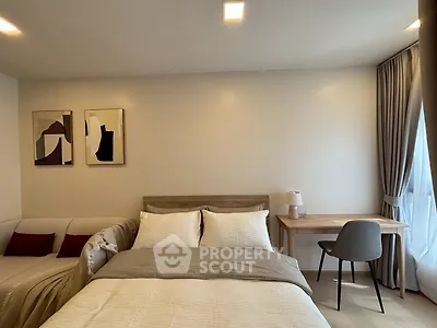 Modern bedroom with cozy bed, stylish decor, and natural light from large window.