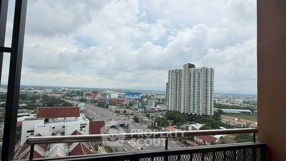Stunning cityscape view from a high-rise balcony overlooking urban skyline and highway.