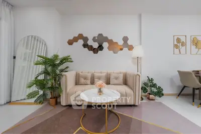 Modern living room with stylish decor, featuring a beige sofa, geometric wall art, and elegant furnishings.
