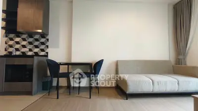 Modern living room with stylish kitchen and cozy seating area in open layout apartment.
