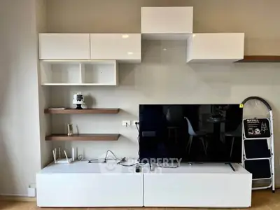 Modern living room with sleek white entertainment unit and wall-mounted shelves